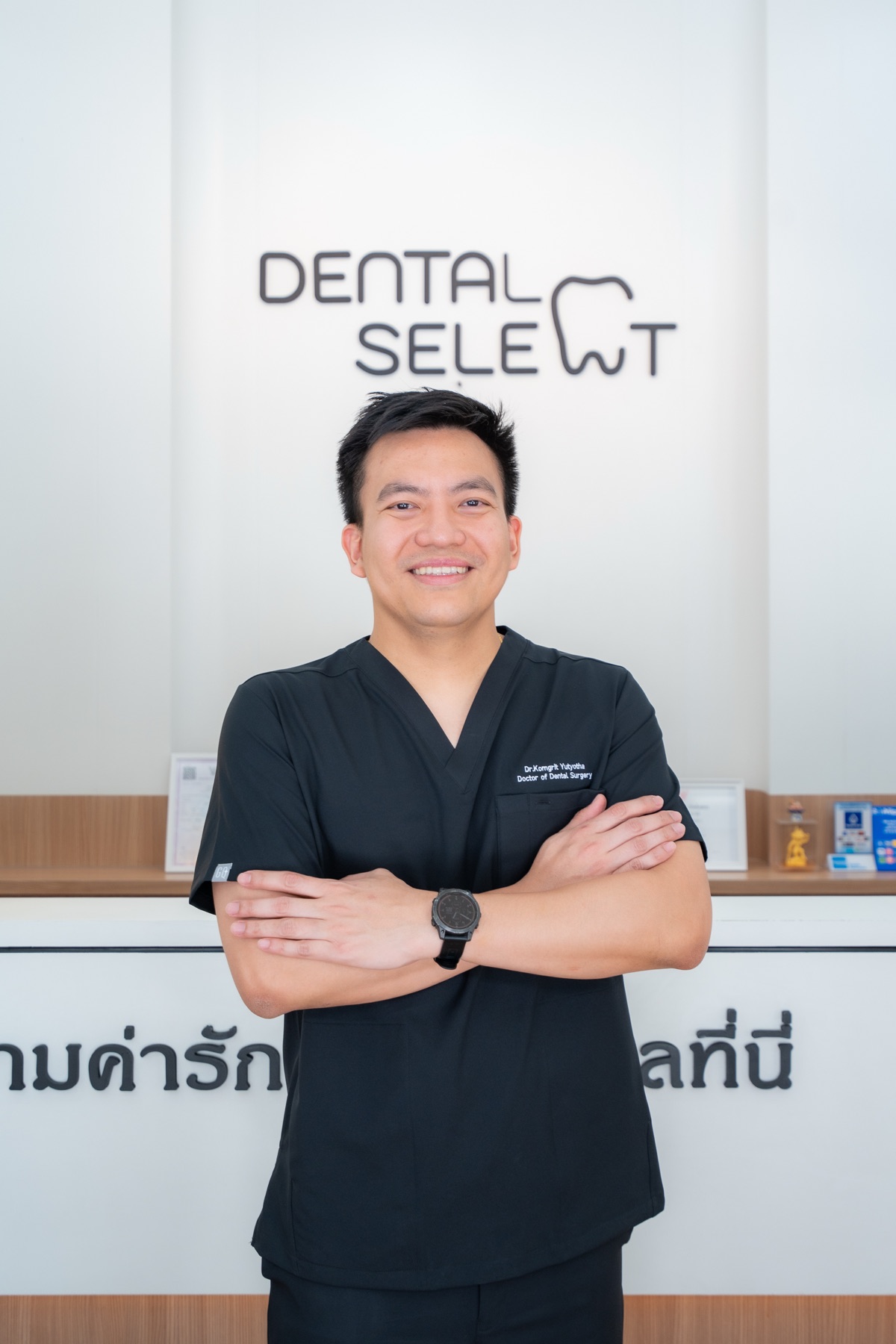 Dr. Komgrit Yutyotha smiling at the Dental Select reception desk in Pattaya